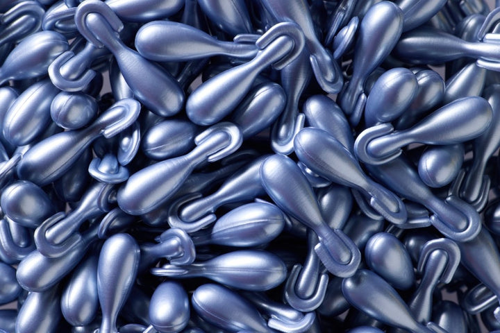 Blau metallisch gefärbte tru face essence gelkapseln mit tropfenform und schlaufen am ageloc tru face produkt