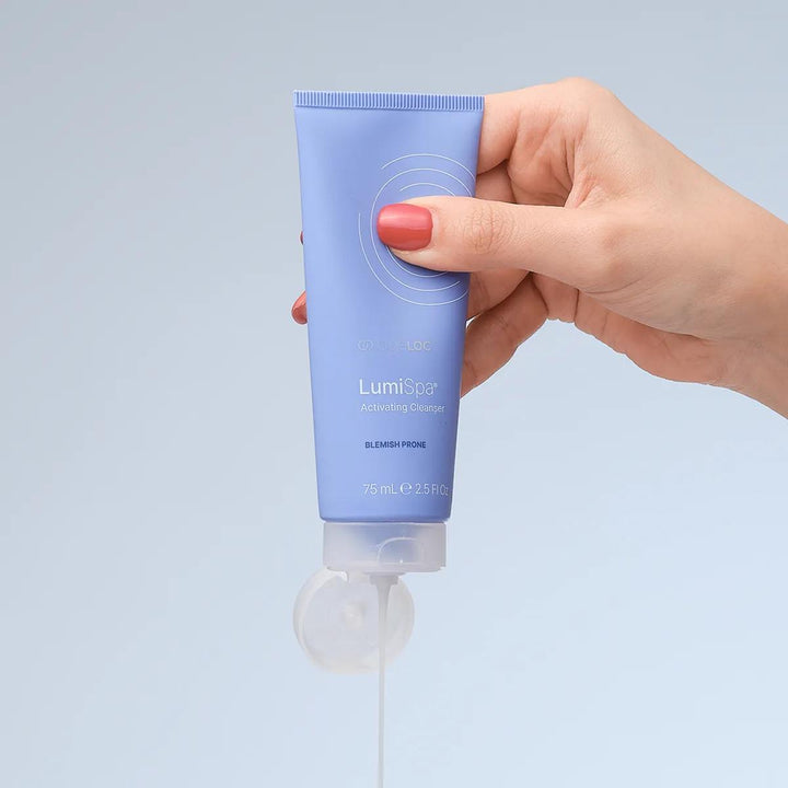 ageLOC LumiSpa Activating Cleanser für zu Unreinheiten neigende Haut: blaue Tube in der Hand