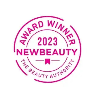 Rundes, rosafarbenes Siegel mit dem Text „award winner 2023 newbeauty the beauty authority“ und einem kleinen Schleifen-Symbol.