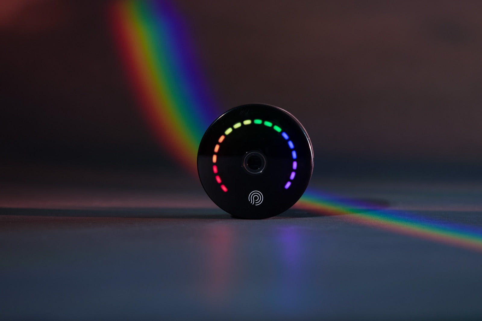 Prysm iO in einem Regenbogen-Lichtstrahl vor dunklem Hintergrund